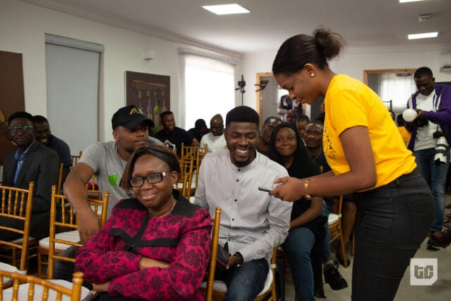 Ibinye sending money to a volunteer at the FinTech 2.0 townhall during Tomi's presentation