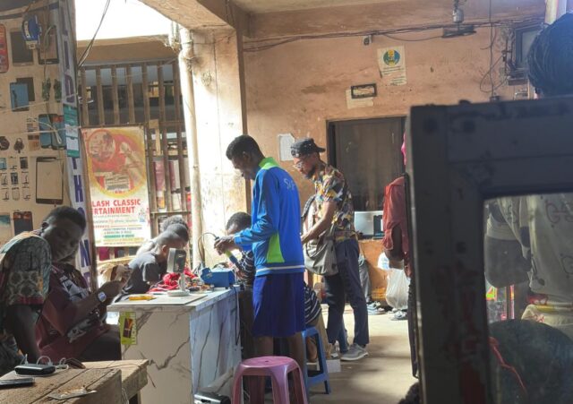 Young apprentice technicians repairing smartphones at a gadget market in Asaba, Nigeria